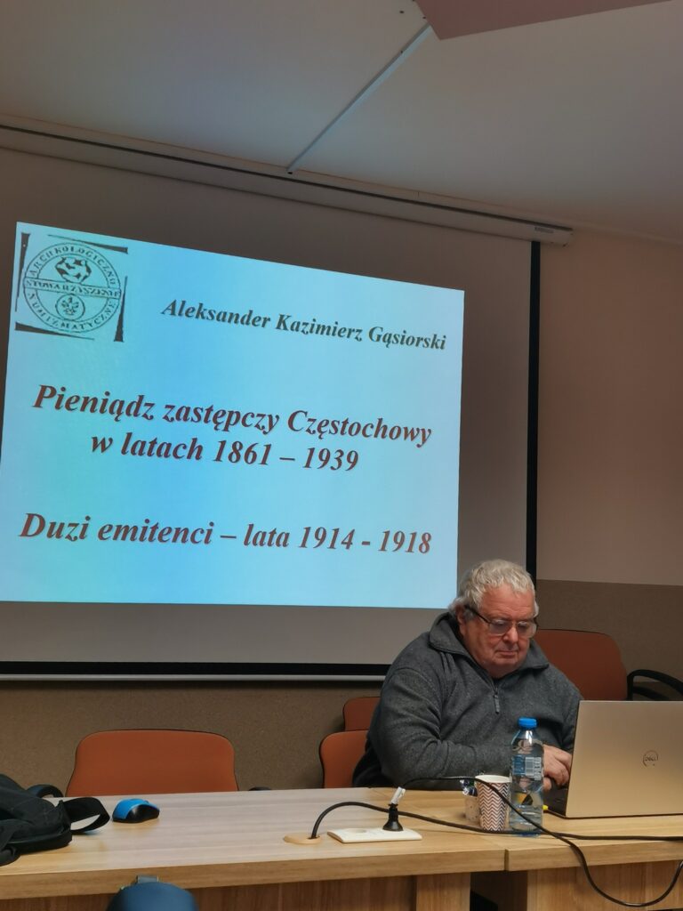Prelegent Aleksander Gąsiorski na tle prezentacji multimedialnej
