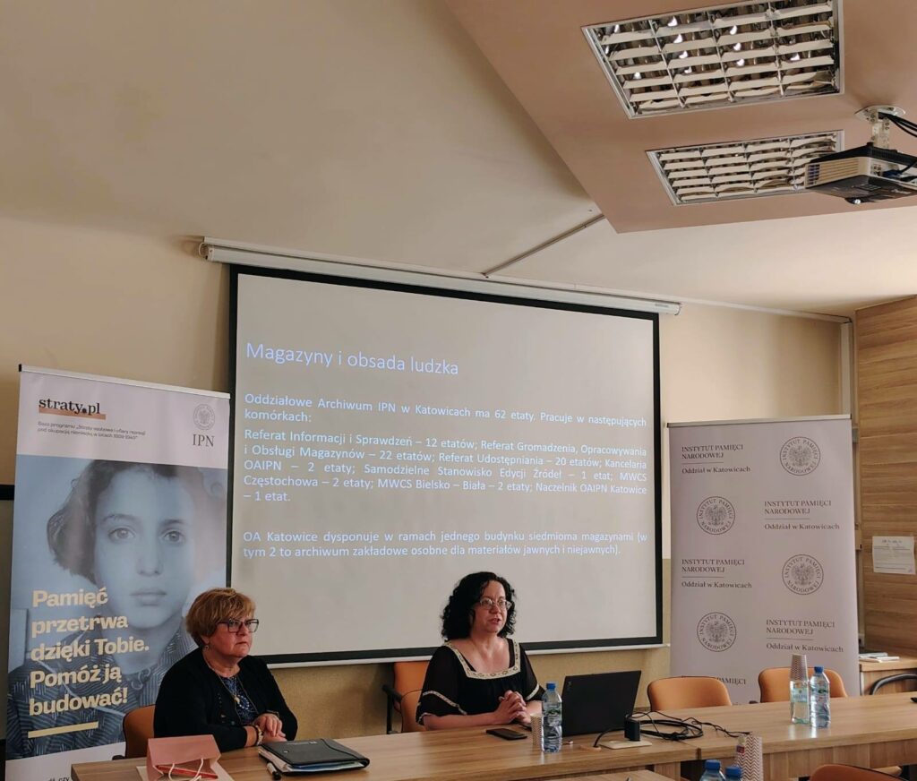 Prezes Julia Dziwoki i prelegentka Renata Dziechcierz na tle prezentacji multimedialnej.