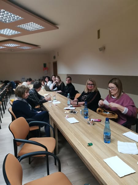 Wszyscy uczestnicy spotkania przy stolikach ustawionych w podkowę.