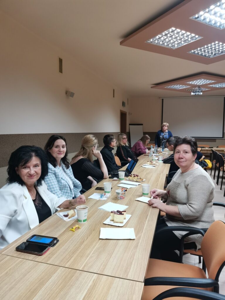 Wszyscy uczestnicy spotkania przy stolikach ustawionych w podkowę.