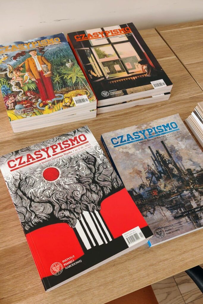 Różne numery periodyku naukowego IPN "CzasyPismo" ułożone na stosach.