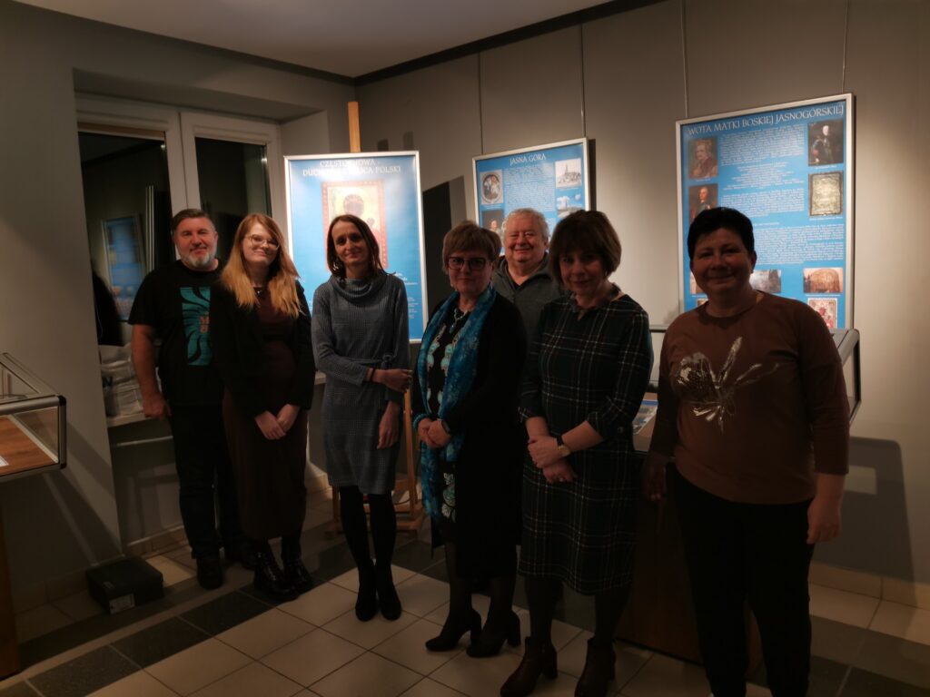 Zdjęcie grupowe na tle wystawy.