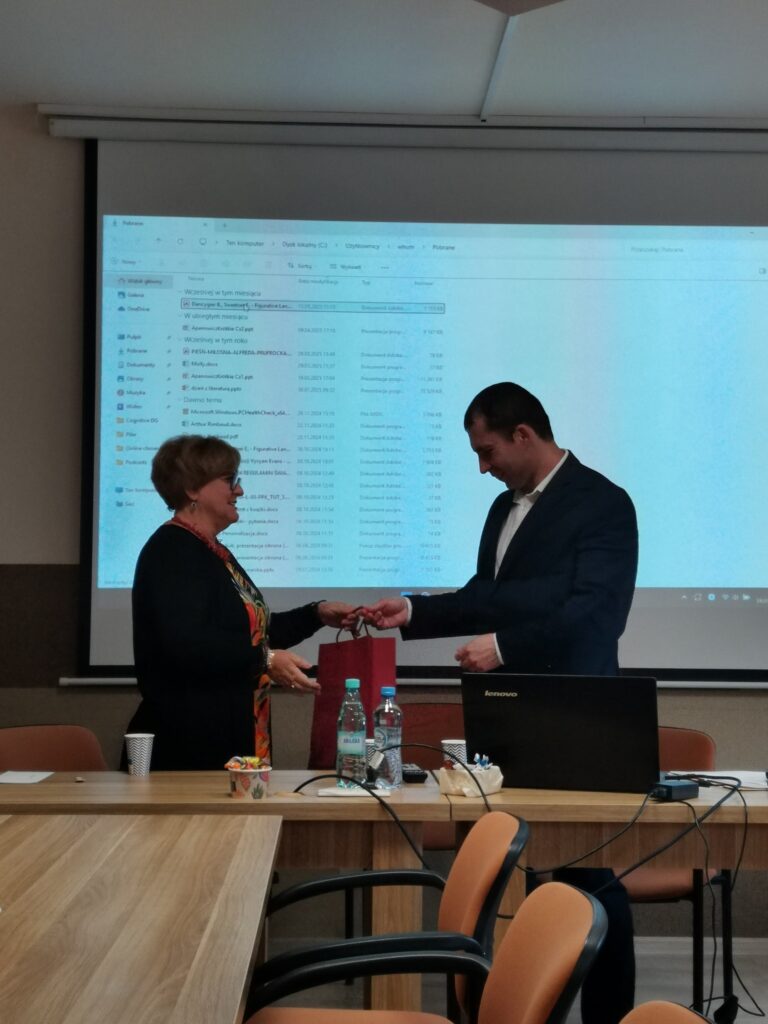 Prezes Julia Dziwoki wręcza upominek prelegentowi.