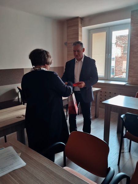 Prezes Julia Dziwoki wręcza upominek prelegentowi.