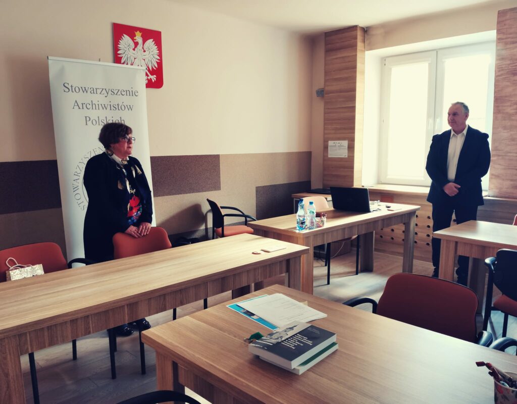 Stoliki z książkami prelegenta. W tle prezes Julia Dziwoki.